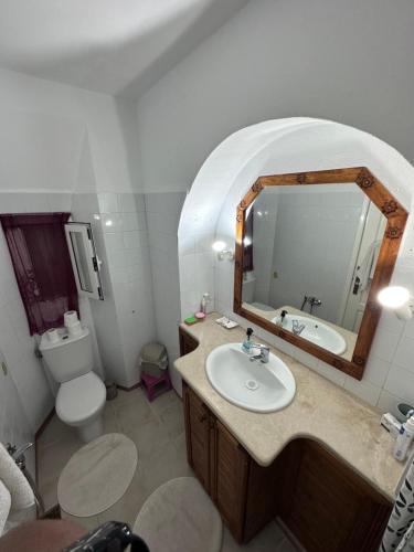 a bathroom with a sink and a toilet and a mirror at Villa viewpoint infinity pool jardin aucun vis-à-vis in Ḩammām al Ghazzāz
