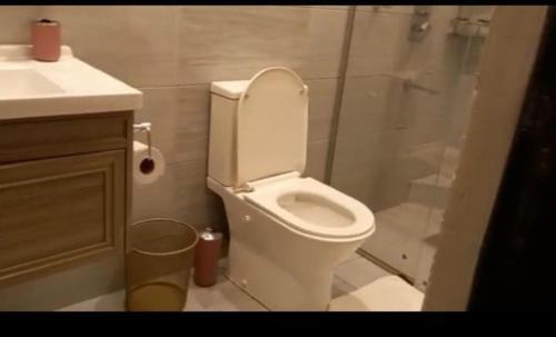 uma casa de banho com um WC branco e um chuveiro em One Bedroom Apartments in Kilimani em Nairobi