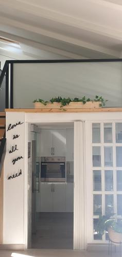 une cuisine avec des placards blancs et une porte menant à une chambre dans l'établissement Casa Loft con terraza vigo, à Vigo