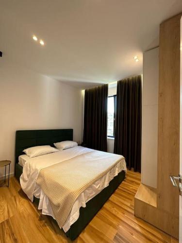 um quarto com uma cama grande num quarto em Sunrise Apartment em Tirana