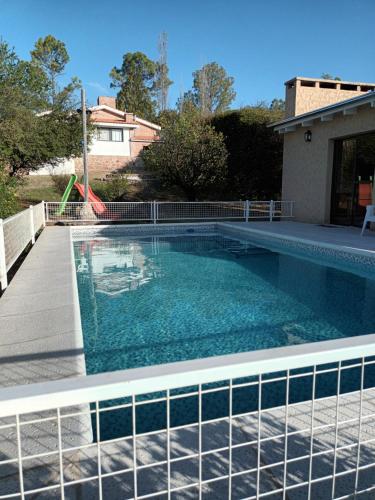 a swimming pool with blue water in a yard at Cabañas Akumali in Nono