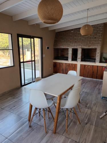 a dining room with a white table and chairs at Cabañas Akumali in Nono
