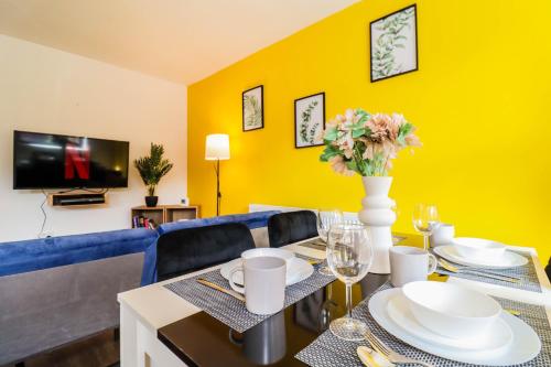 a dining room with a table and a blue couch at Spacious 1 bed flat-FREE Parking in New Bedfont