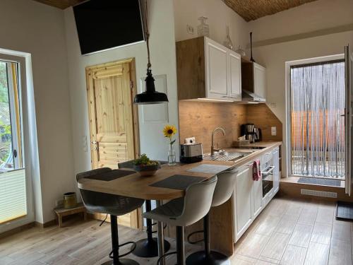 a kitchen with a table and some chairs and a sink at FeWo Hof-Idyll mit FassSauna / Spielplatz für Kids in Weißwasser