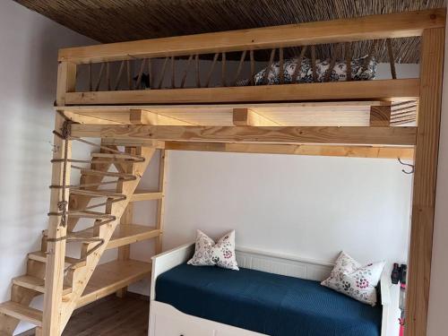 a bunk bed with a blue couch in a room at FeWo Hof-Idyll mit FassSauna / Spielplatz für Kids in Weißwasser