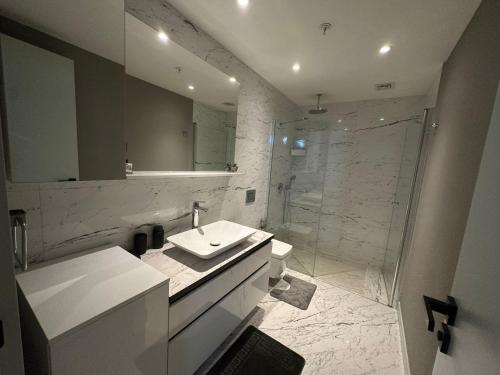 ein weißes Bad mit einem Waschbecken und einer Dusche in der Unterkunft most luxury 2+1 apt at sinpas queen bomonti f 40-90 in Istanbul