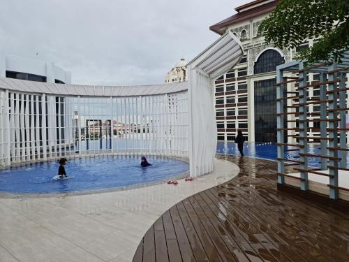 哥打巴魯的住宿－Sakifa's Home @ Troika Kota Bharu，两人在大楼的游泳池里