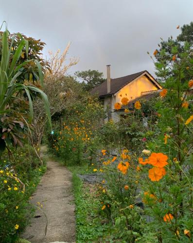 a path leading to a house with a field of flowers at Romantic house 2 on a pine hill Dalat in Da Lat
