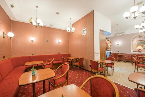 a restaurant with tables and chairs and a couch at Erzsébet Park Hotel in Parád