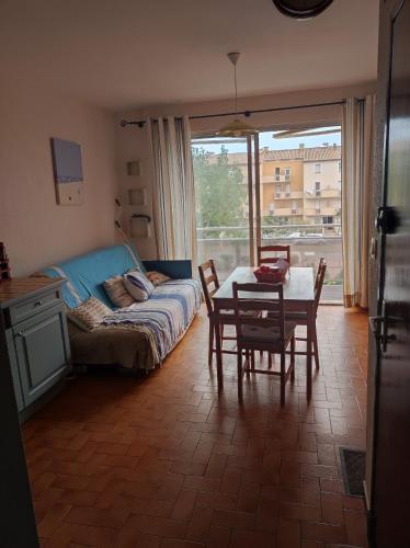 ein Wohnzimmer mit einem Sofa und einem Tisch mit Stühlen in der Unterkunft Chez Armelle in Port-la-Nouvelle