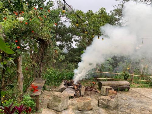 a pile of logs with smoke coming out of it at Romantic house 2 on a pine hill Dalat in Da Lat