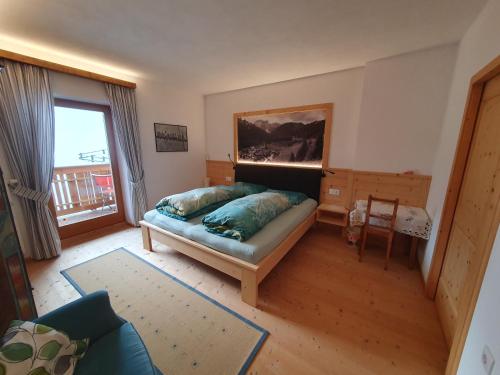 a bedroom with a bed and a large window at Apartement Schuster Lake Prags Braies in Braies