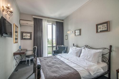Habitación de hotel con cama, escritorio y ventana en Prestige Palace - Esquisse Hotel, en Tiflis