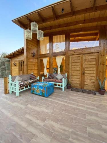 a wooden cabin with two beds on a patio at كوخ آفيري Aviary Hut in AlUla