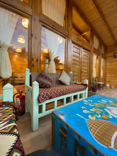 a bedroom with a bed in a wooden cabin at كوخ آفيري Aviary Hut in Al-ʿUla