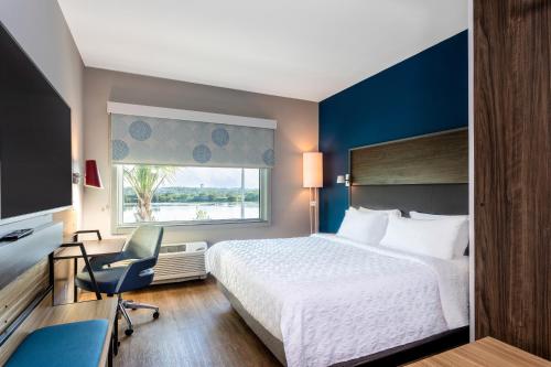 a hotel room with a bed and a chair and a window at Tru By Hilton Port St Lucie Tradition in Port Saint Lucie
