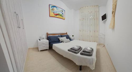 een slaapkamer met een bed met twee schoenen erop bij Bonito piso en MarinaDor in Castellón de la Plana