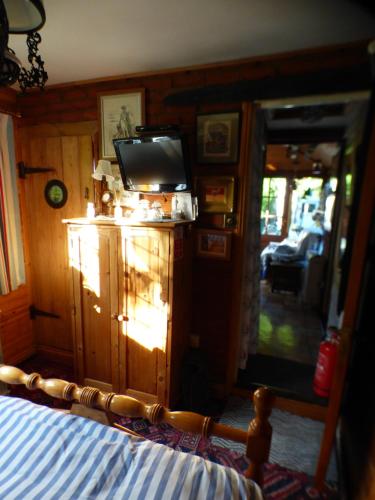 1 dormitorio con TV en la parte superior de un tocador en NELSONS CABIN, en North Creake