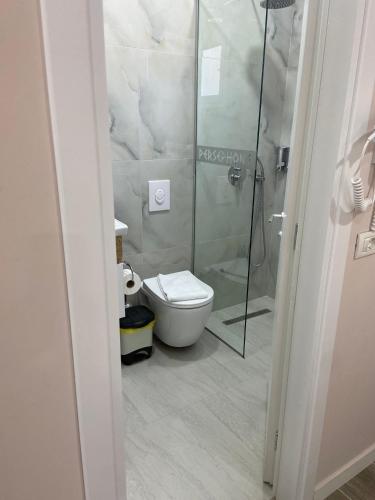 a bathroom with a toilet and a glass shower at Persephone in Himare