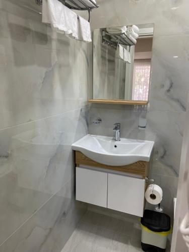 a white bathroom with a sink and a mirror at Persephone in Himare