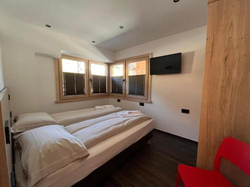 a large bed in a room with windows at Gin Luxury Apartments City Centre in Livigno