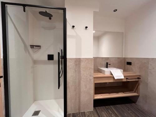y baño con ducha y lavamanos. en Gin Luxury Apartments City Centre, en Livigno
