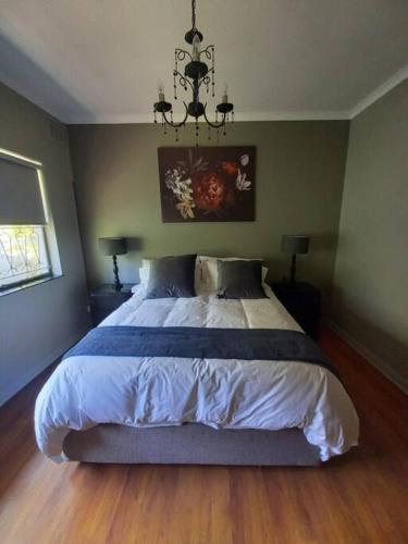 a bedroom with a large bed and a chandelier at The Miller's Airbnb in Cape Town