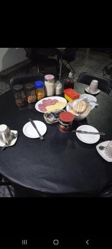 una mesa negra con platos y utensilios. en HOSTAL CHILLAN FAMILIAR, en Chillán