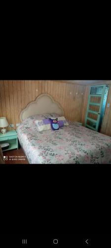 1 dormitorio con 1 cama con manta morada en HOSTAL CHILLAN FAMILIAR, en Chillán