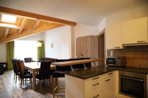 a kitchen and dining room with a table and chairs at A Casa Saphir Appartement-Hotel in Sölden