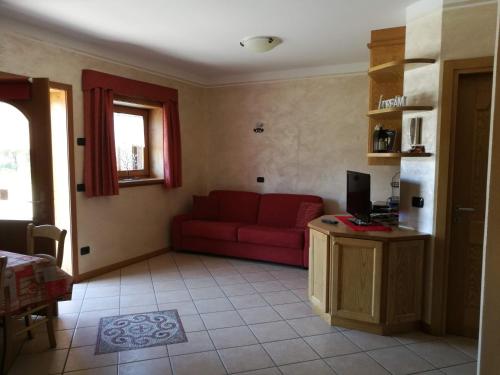 uma sala de estar com um sofá vermelho e uma televisão em Chalet Claudia em Livigno