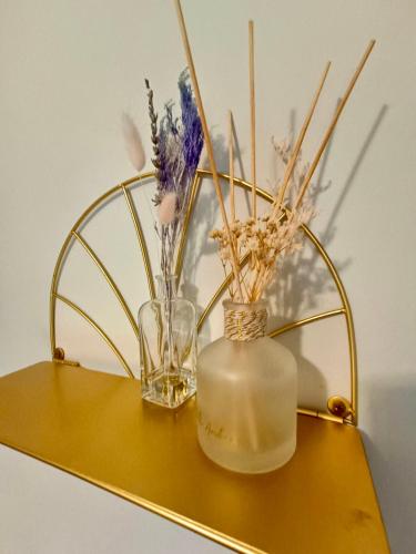a gold shelf with a glass vase and flowers on it at Rosa House in Darlington