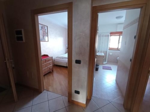 pokój z drzwiami otwierającymi się na sypialnię z łóżkiem w obiekcie Chalet Claudia w Livigno
