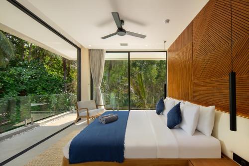 セロング・ベラナクにあるVilla Selong Belanak - Private Beach Accessのベッドと大きな窓のある寝室