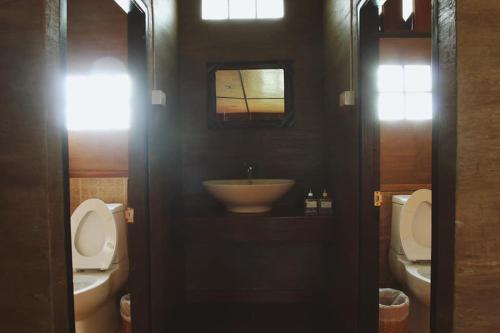 a bathroom with two toilets and a sink at Phuruarounmai Organic Living Resort in Loei