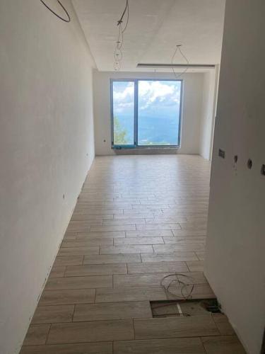 an empty room with a large window and a tile floor at G Apartments Milmari Resort & Spa (Lux) in Kopaonik
