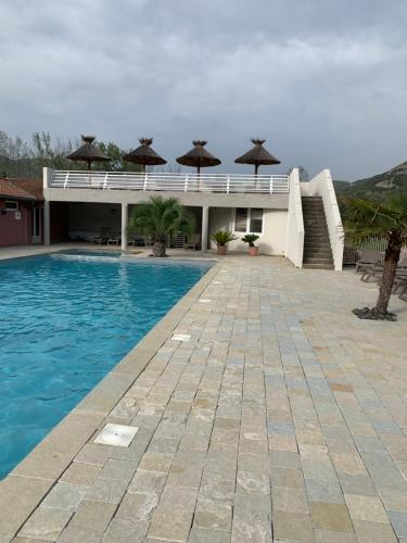 a house with a swimming pool with umbrellas at Calme & Sérénité in Saint-Julien-en-Saint-Alban
