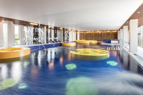 a swimming pool in a building with blue water at Estonia Resort Hotel & Spa in Pärnu