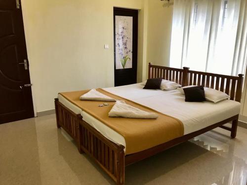 Cette chambre comprend un grand lit et une grande fenêtre. dans l'établissement Arabian Pearl, à Fort Kochi