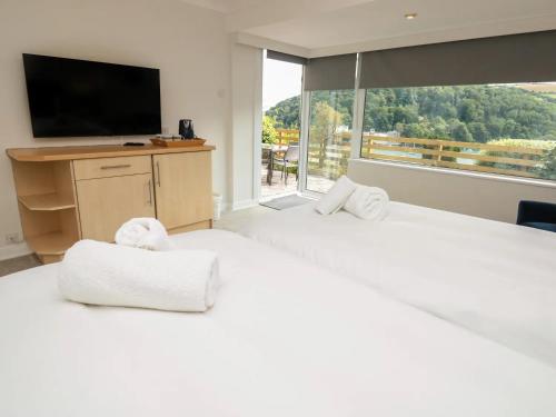 a bedroom with two white beds and a large window at Pine Lodge - Private Parking in Kingswear