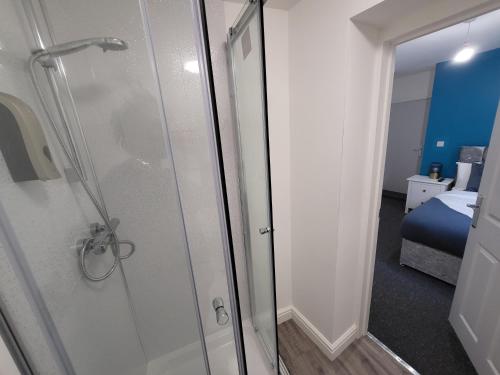 baño con ducha y puerta de cristal en Nottingham Forest Rd, Short Stays, en Nottingham