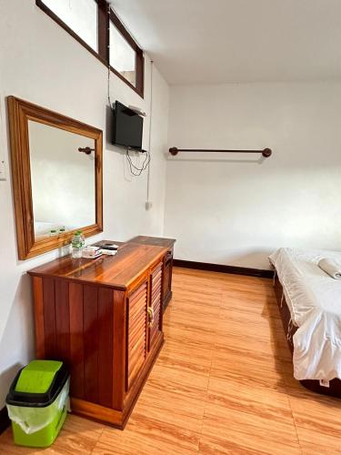 a bathroom with a sink and a mirror and a bed at Vang Vieng Global Hostel in Vang Vieng