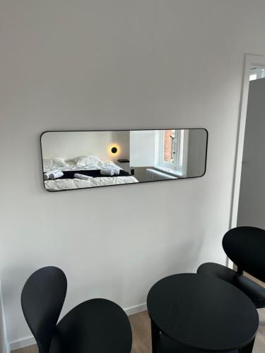 a mirror in a room with two black chairs at D28 Bruges in Bruges