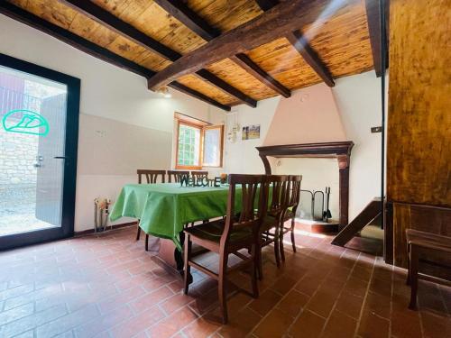 ein Esszimmer mit einem grünen Tisch und Stühlen in der Unterkunft Casa del Viandante Borgo dei Sassi di Roccamalatina in Guiglia