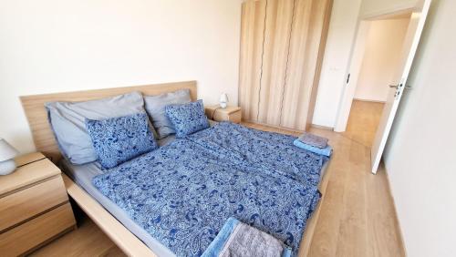 a bedroom with a bed with blue sheets and pillows at Luxo 2 Room Apartments by Bratislavatrip in Bratislava