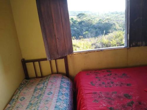 een kleine kamer met een bed en een raam bij Sítio Candeias - Diamantina MG in Diamantina