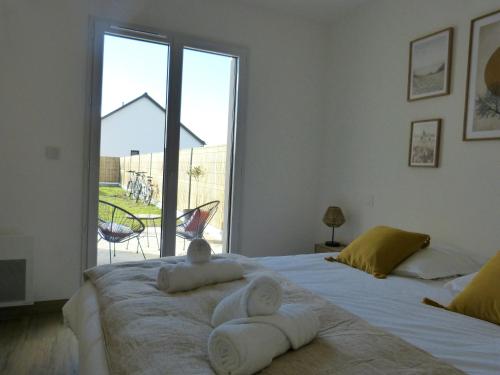 Villa Ty Plad, Penmarc'h في بينمارش: غرفة نوم بسريرين ونافذة كبيرة
