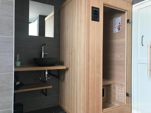 a bathroom with a sink and a mirror at Ruim appartement met sauna, Zuidstraat 125 in Westkapelle in Westkapelle