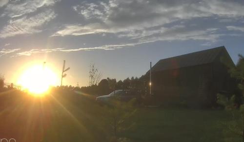 a truck parked in a parking lot with the sun setting at Domek mazurski całoroczny nad jeziorem z Sauną fińską I Jacuzzi SPA in Pasym