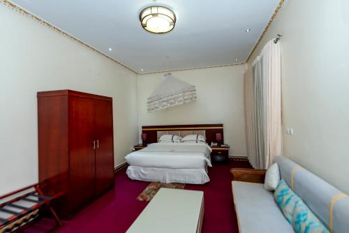 a hotel room with a bed and a couch at Dove Hotel Kigali in Kigali